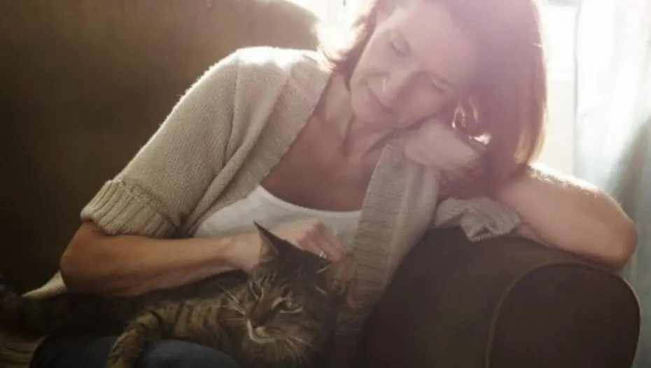 Жінка гладить свого кота